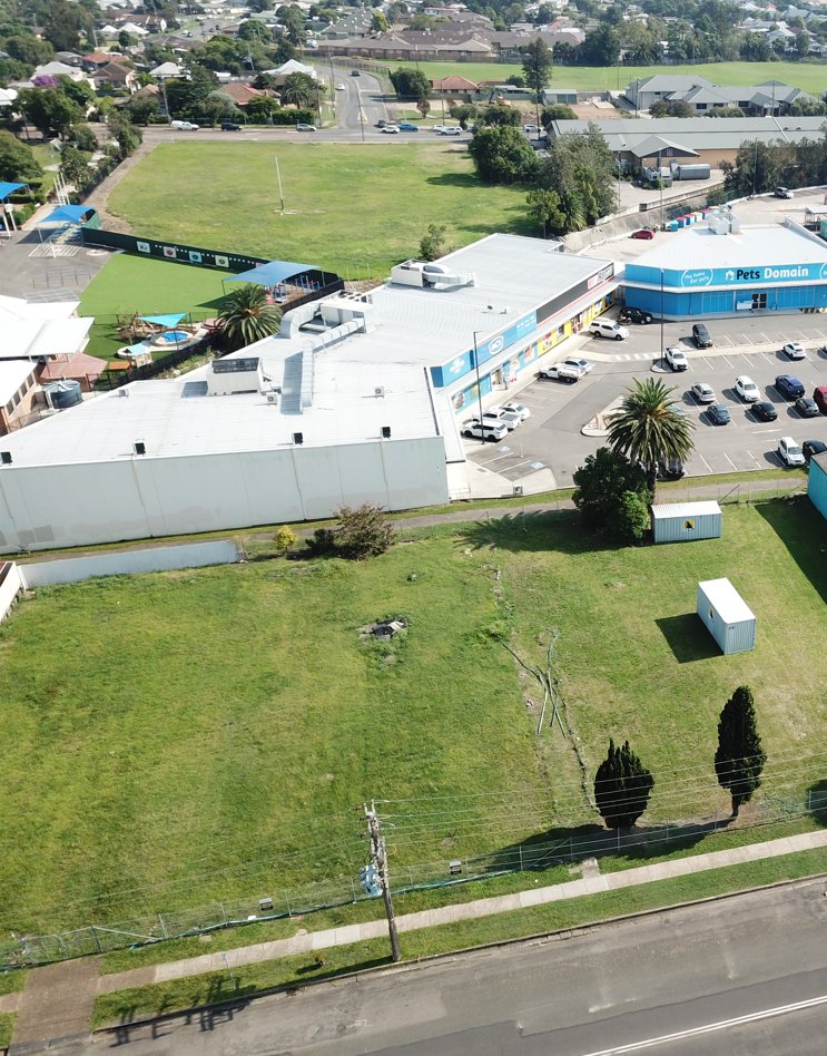 Aerial view of a commercial site beside a retail centre